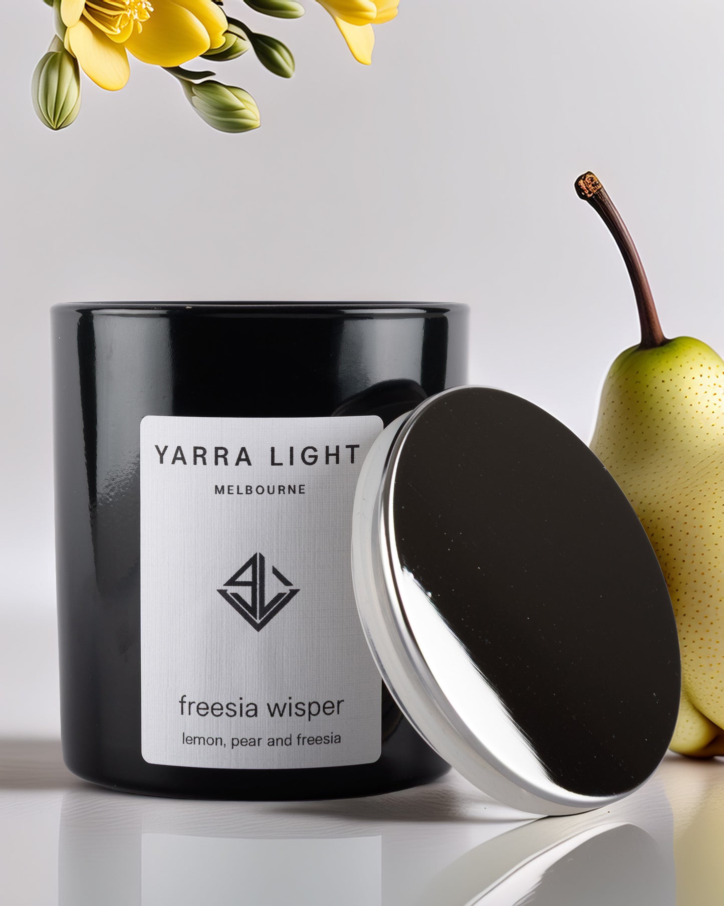 Yarra Light soy wax candle with a pear and yellow flowers on a light background