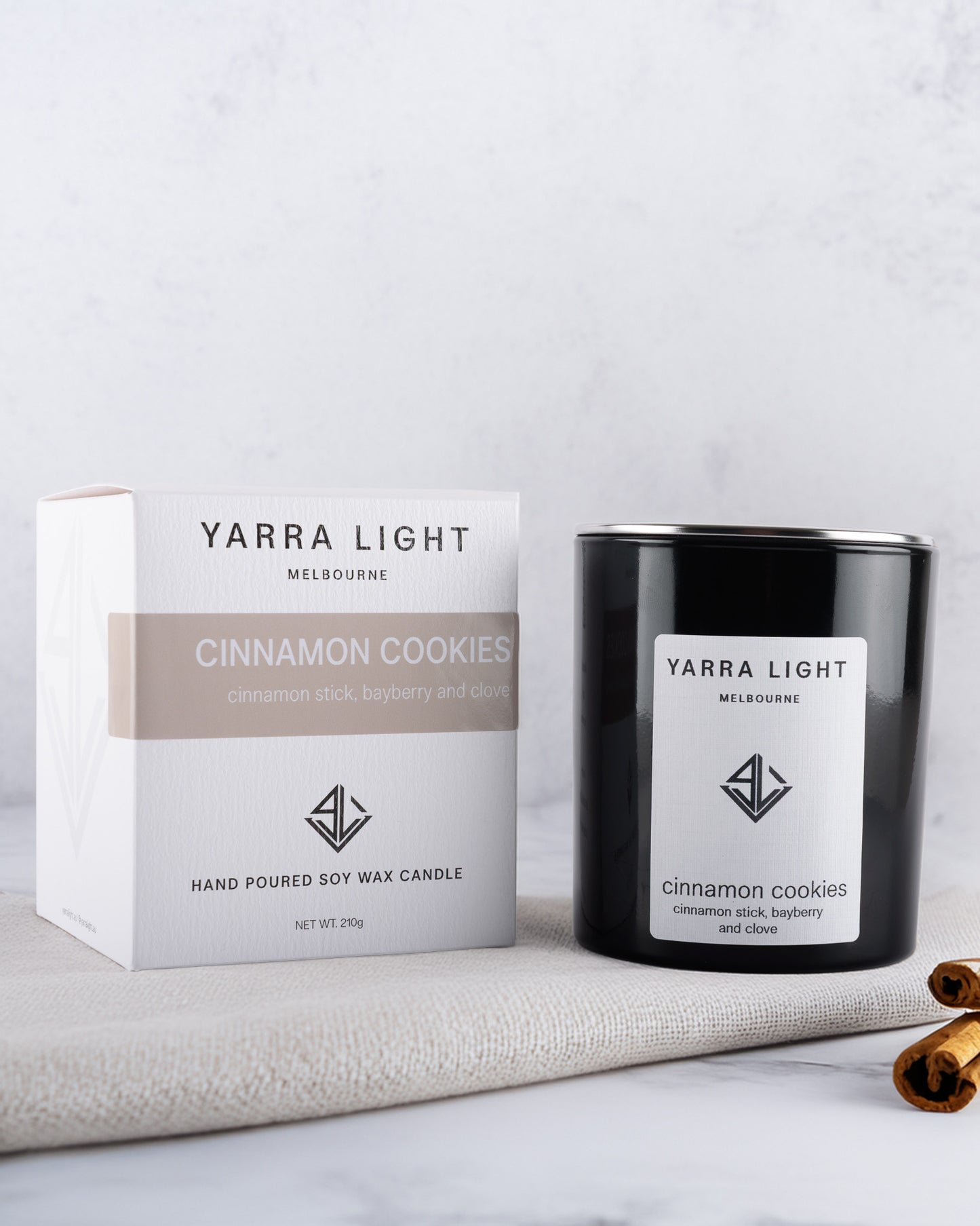 Yarra Light cinnamon cookies soy wax candle and packaging on a white surface