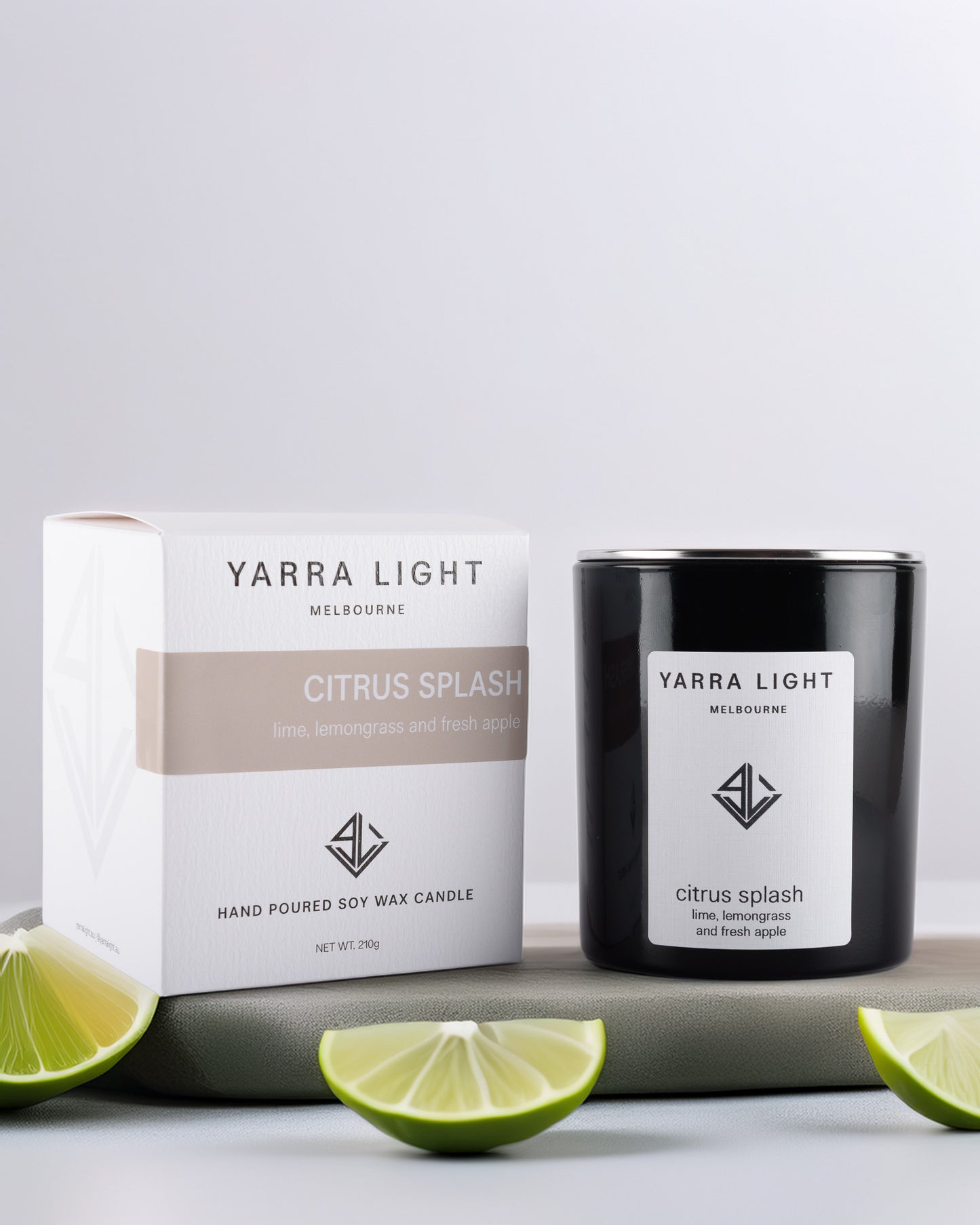 Yarra Light Citrus Splash soy wax candle and packaging on a light gray background with lime slices.