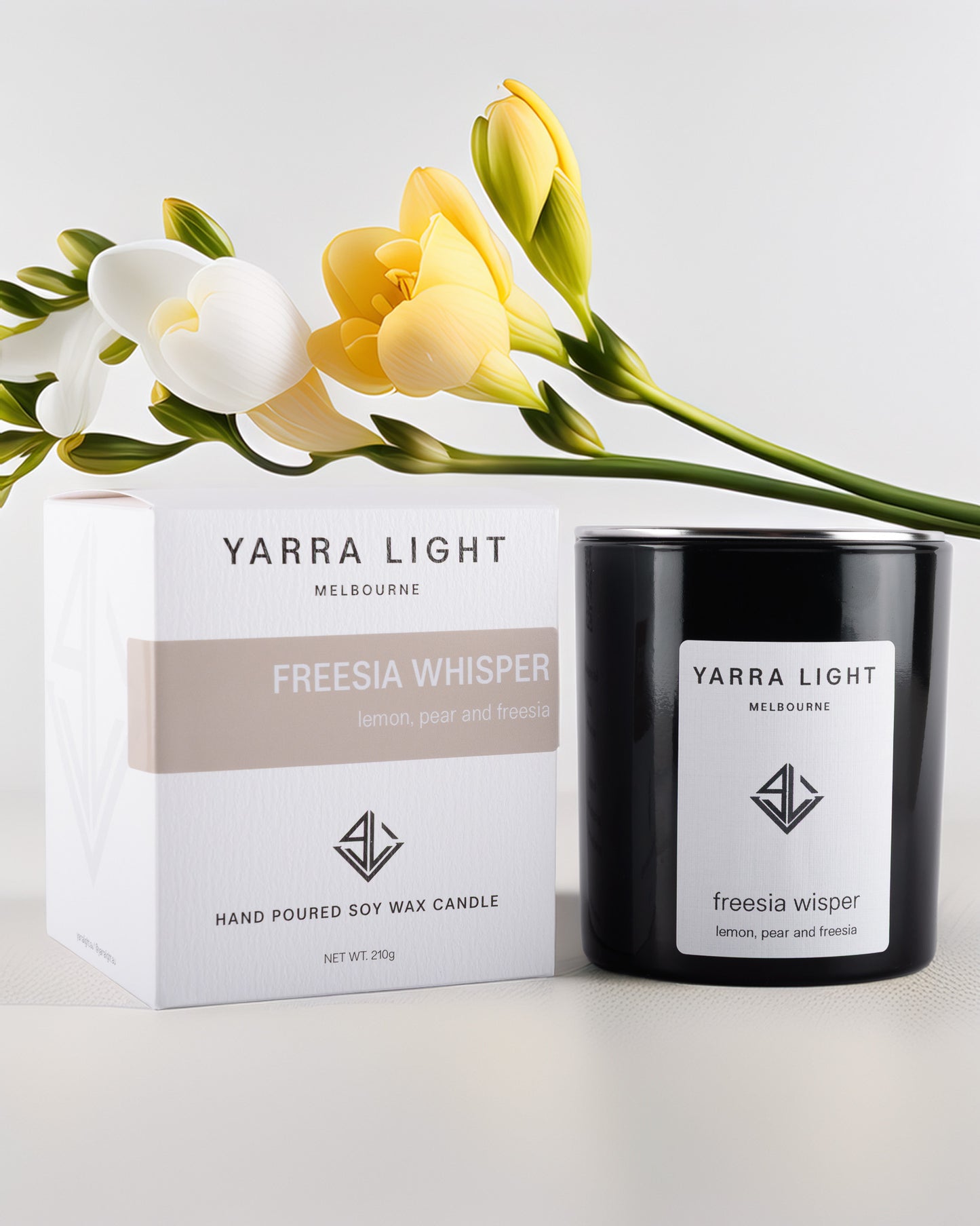 Yarra Light Freesia Whisper soy wax candle and packaging with flowers on a light background
