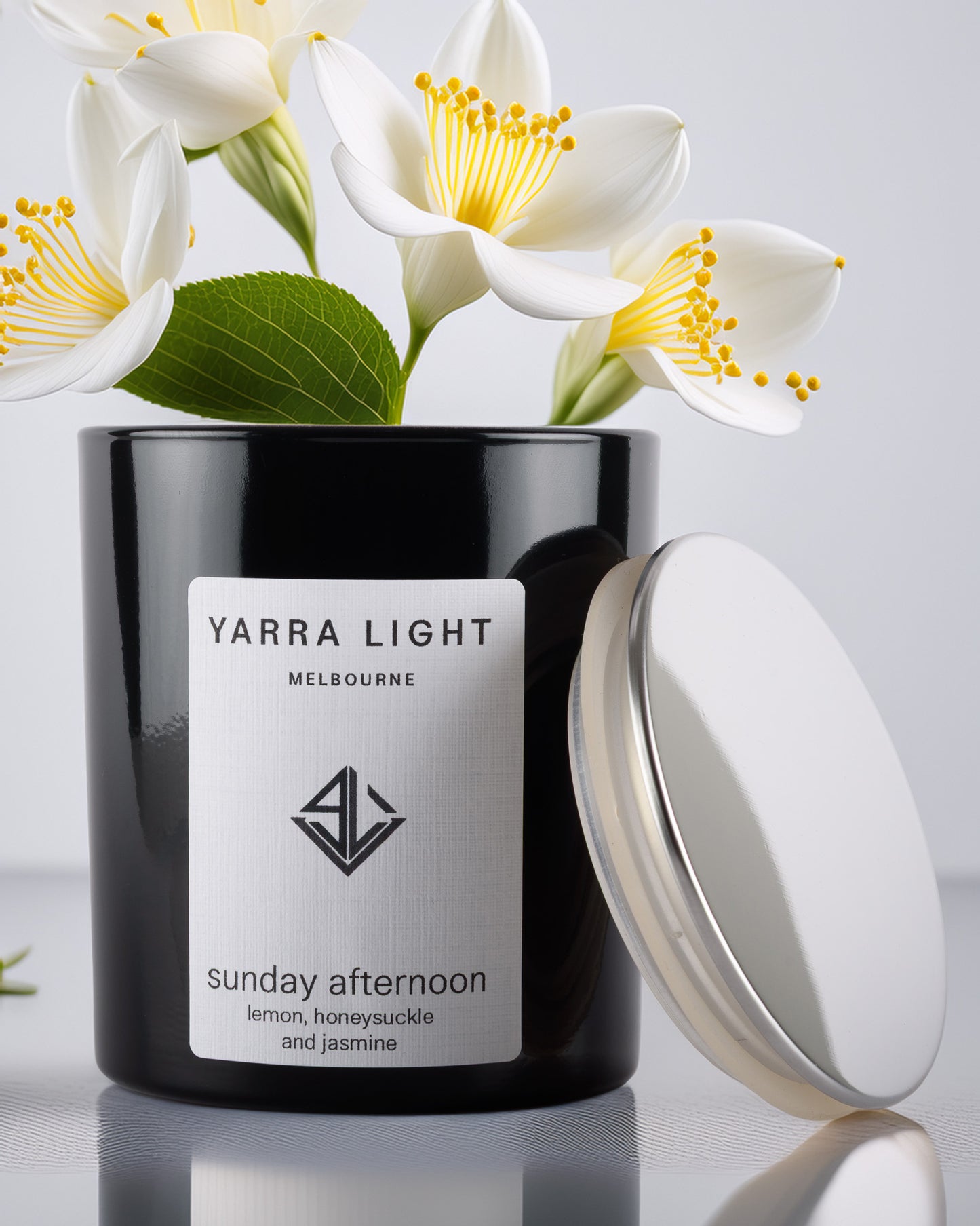 Yarra Light soy wax candle with white flowers in the background