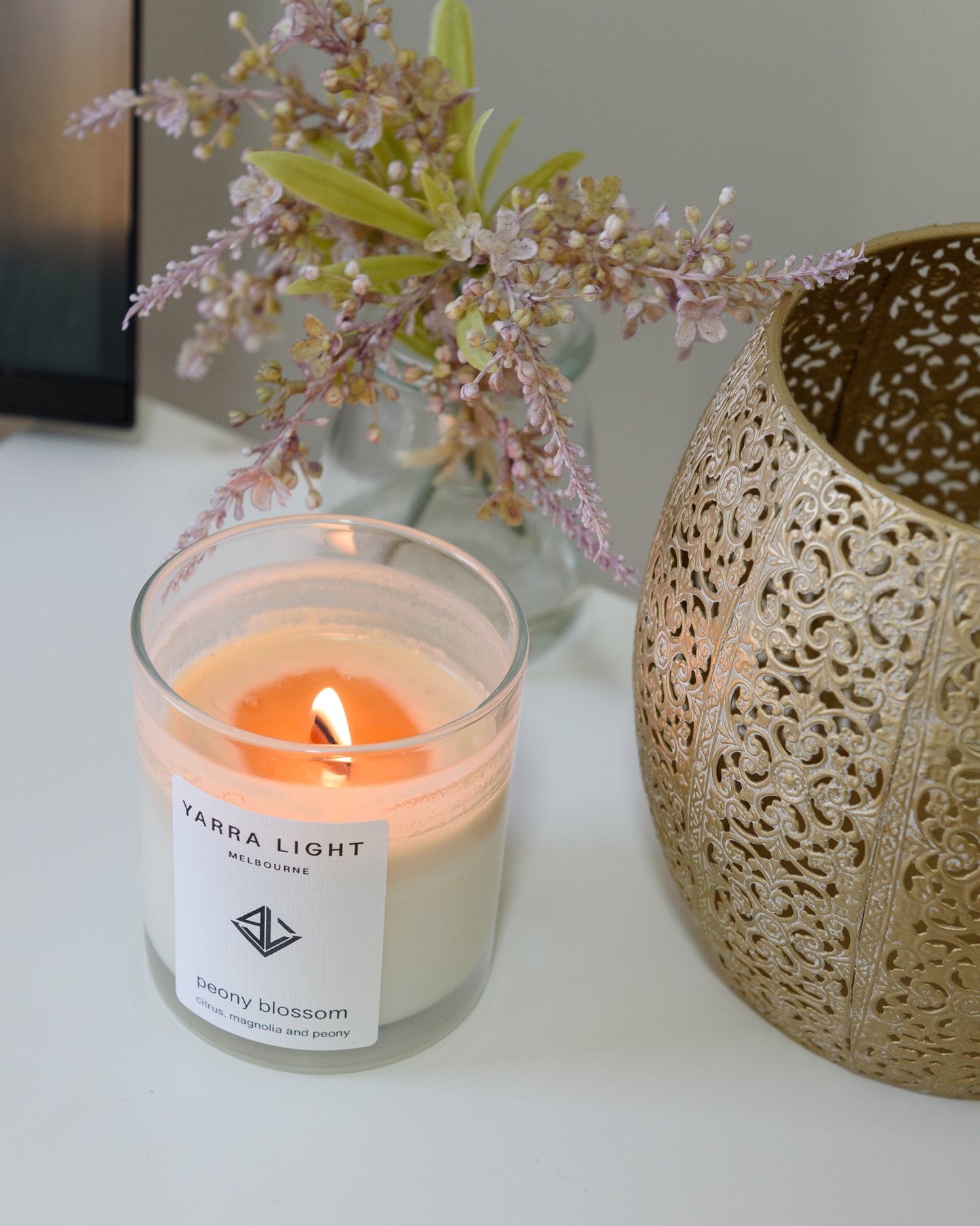 Peony Blossom soy wax scented candle with wood wick in a clear glass jar with minimalist label, inspired by the delicate and romantic fragrance of blooming peonies.