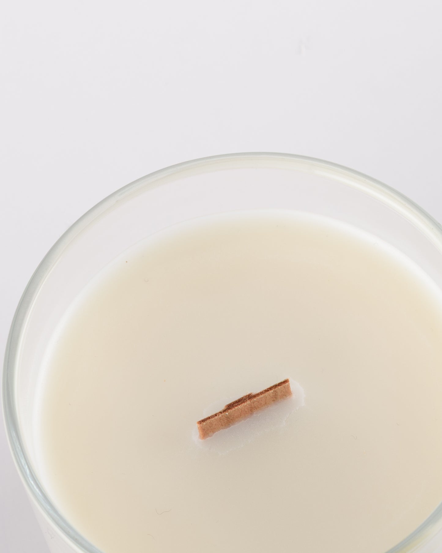 soy wax scented candle with wood wick in a glass jar with minimalist label.