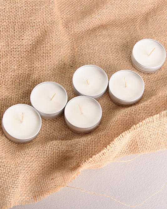 Six soy wax sample candles in small metal tins arranged on hessian cloth