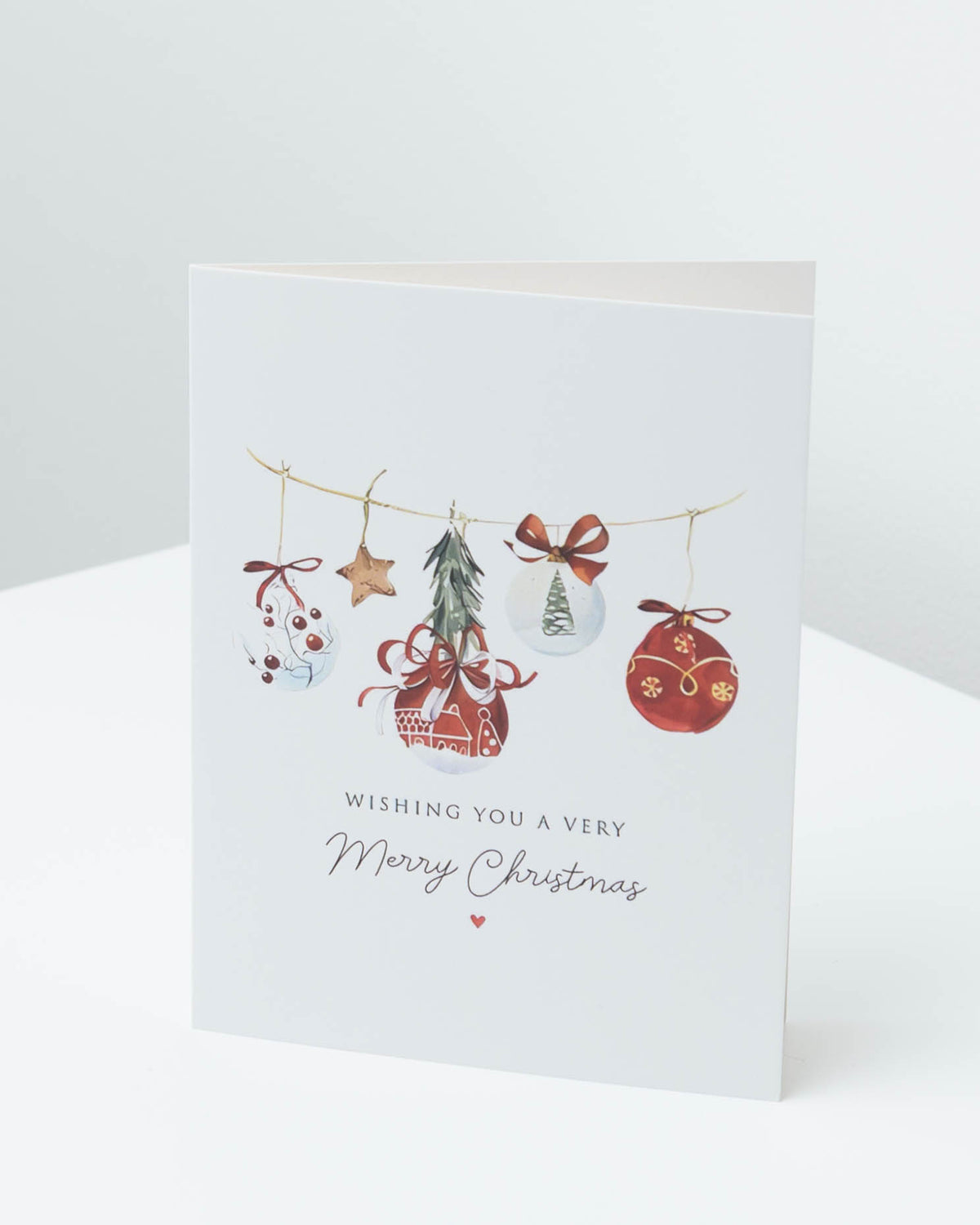 Christmas card with watercolour hanging baubles, a star and a small tree, reading Wishing you a very Merry Christmas