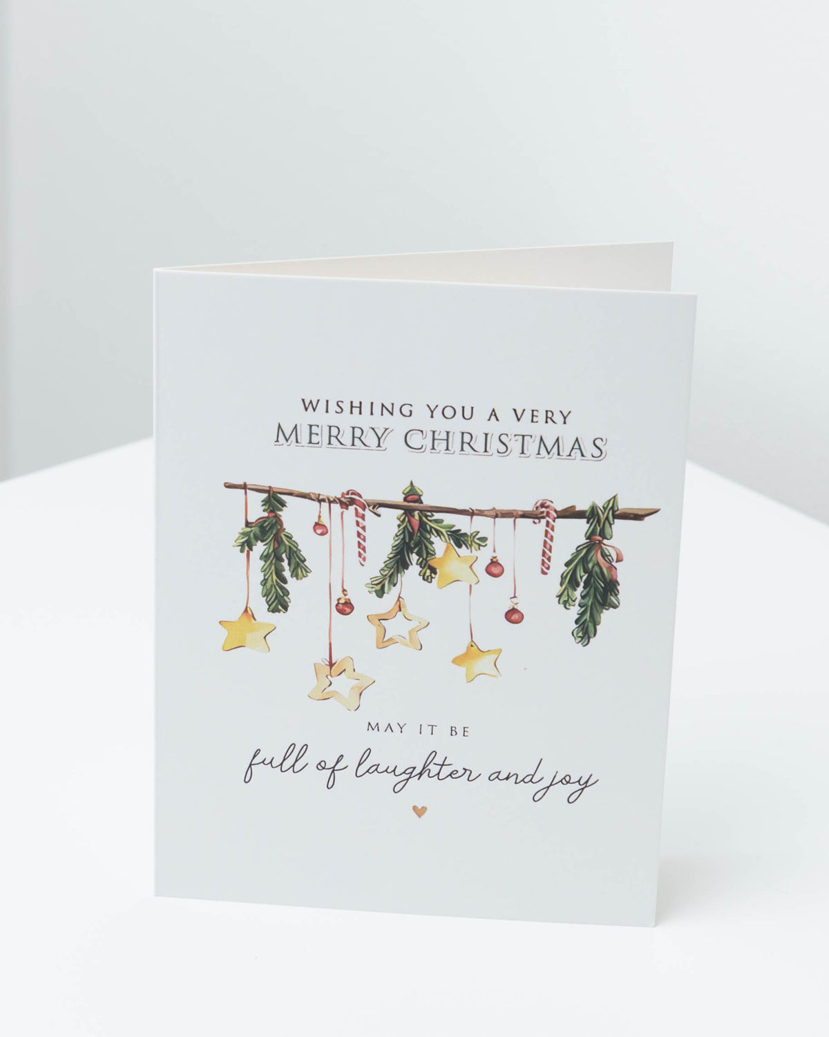 Christmas card with a garland of pine sprigs, candy canes and gold stars, reading Wishing you a very Merry Christmas, may it be full of laughter and joy