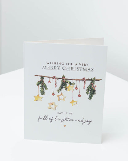 Christmas card with a garland of pine sprigs, candy canes and gold stars, reading Wishing you a very Merry Christmas, may it be full of laughter and joy