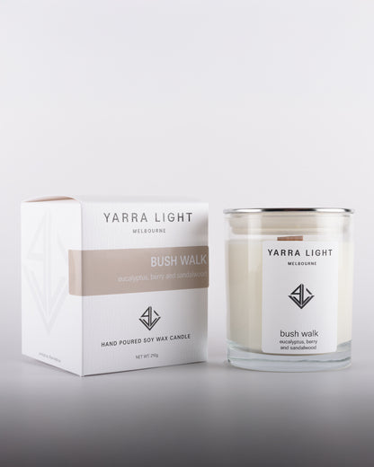 Bush Walk soy wax scented candle in a clear glass jar with minimalist label, positioned next to its eco-friendly packaging box, inspired by Australian bushland.