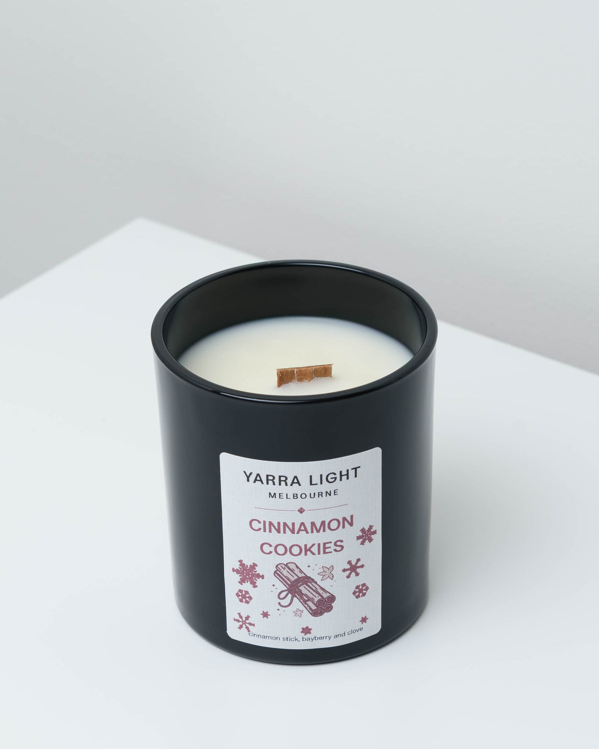Cinnamon Cookies Christmas soy candle in black glass with a wood wick and a cinnamon stick label