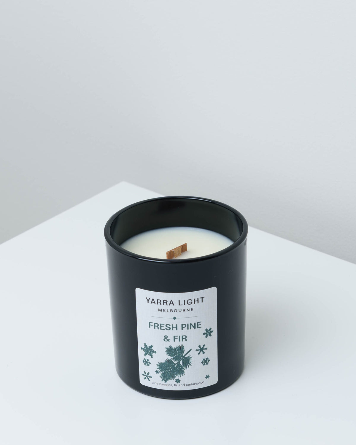 Fresh Pine & Fir Christmas soy candle in black glass with a wood wick and a pine sprig label