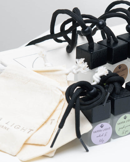 Collection of hanging car diffusers in glass bottles, featuring a variety of long-lasting fragrances for cars and small spaces.