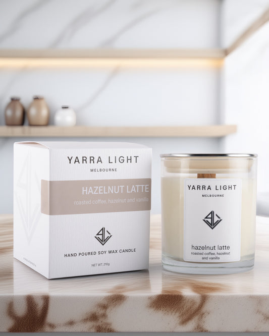 Yarra Light hazelnut latte soy wax candle and packaging on a marble surface