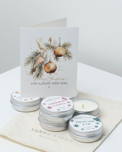Mini Christmas candle bundle: 20g soy candle tins in Cinnamon Cookies and Fresh Pine & Fir on a cotton pouch, with a gold baubles Merry Christmas card