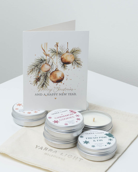 Mini Christmas candle bundle: 20g soy candle tins in Cinnamon Cookies and Fresh Pine & Fir on a cotton pouch, with a gold baubles Merry Christmas card