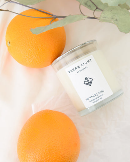 Yarra Light soy wax candle with oranges and leaves on a light background