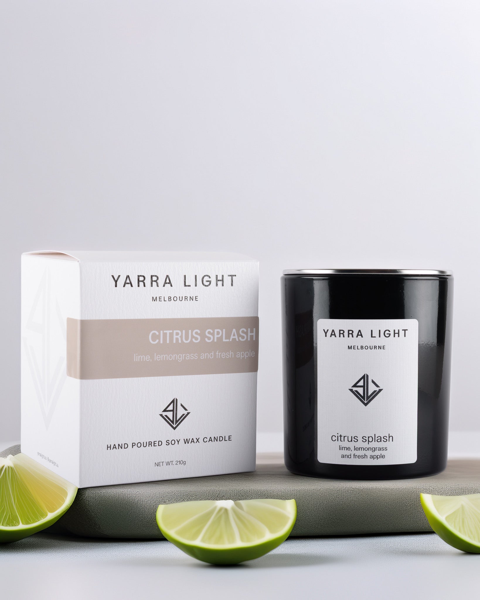 Yarra Light Citrus Splash soy wax candle and packaging on a light gray background with lime slices.