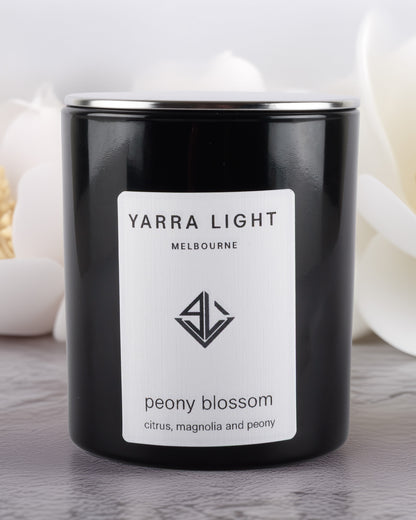 Yarra Light peony blossom soy wax candle on a wooden surface
