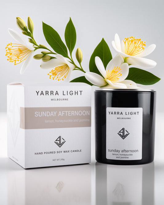 Yarra Light soy wax candle and packaging with flowers on a light background