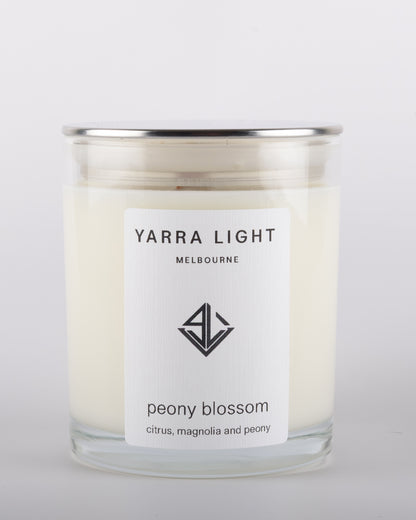 Peony Blossom soy wax scented candle with wood wick in a clear glass jar with minimalist label, inspired by the delicate and romantic fragrance of blooming peonies.