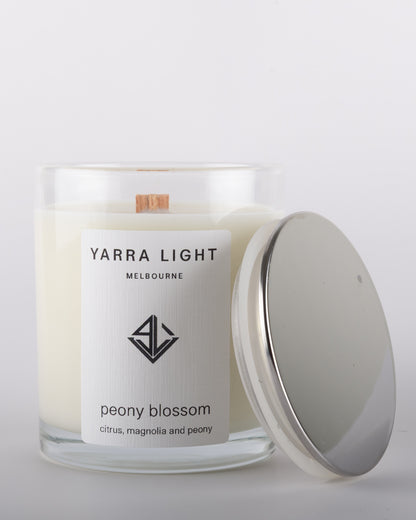 Peony Blossom soy wax scented candle with wood wick in a clear glass jar with minimalist label, inspired by the delicate and romantic fragrance of blooming peonies.