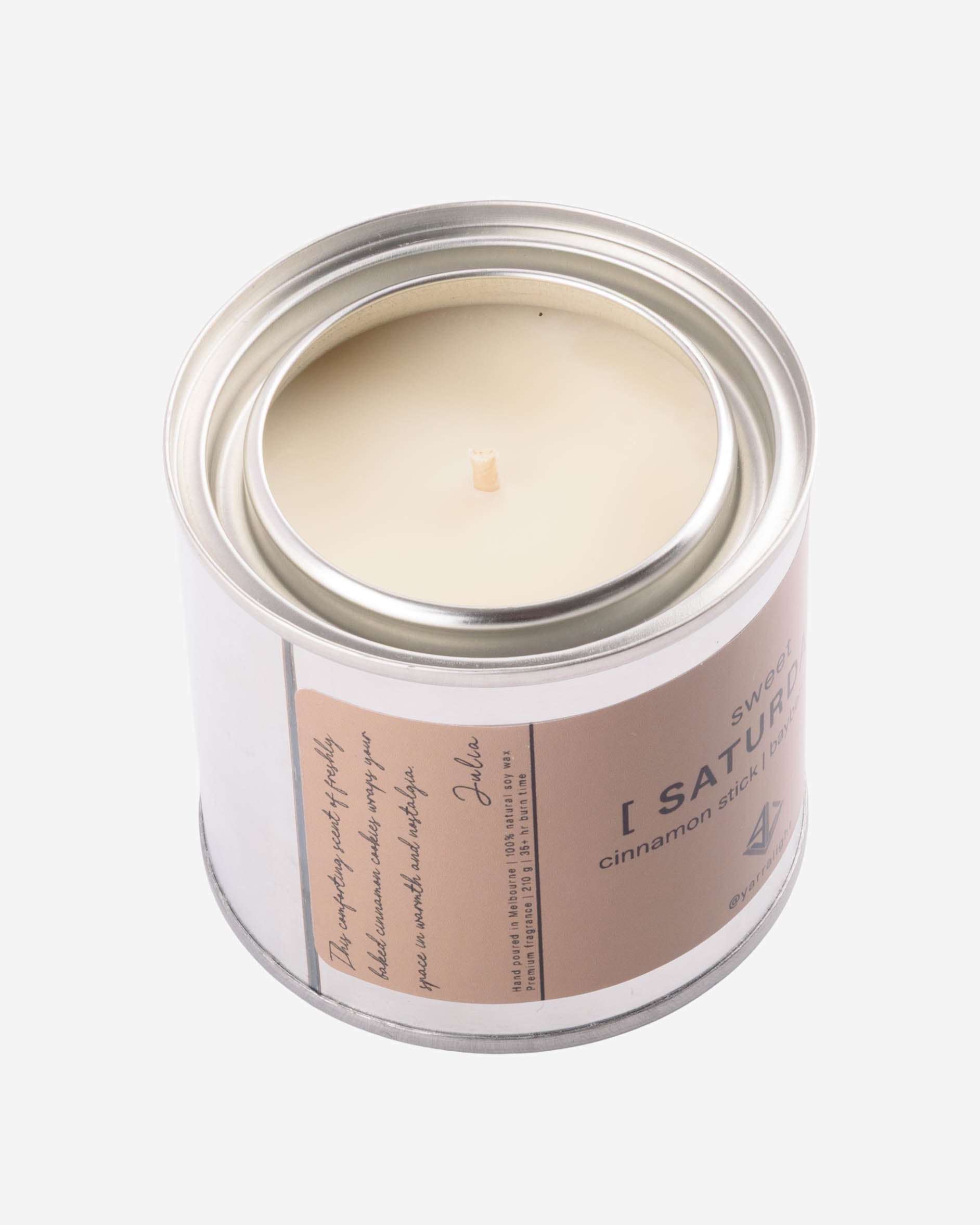 Hand poured soy wax candle in a metal jar with a label on a white background