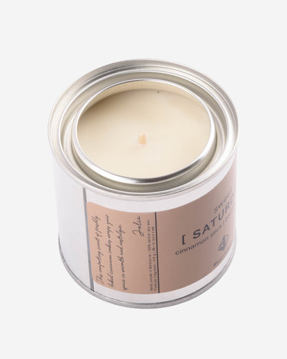 Hand poured soy wax candle in a metal jar with a label on a white background