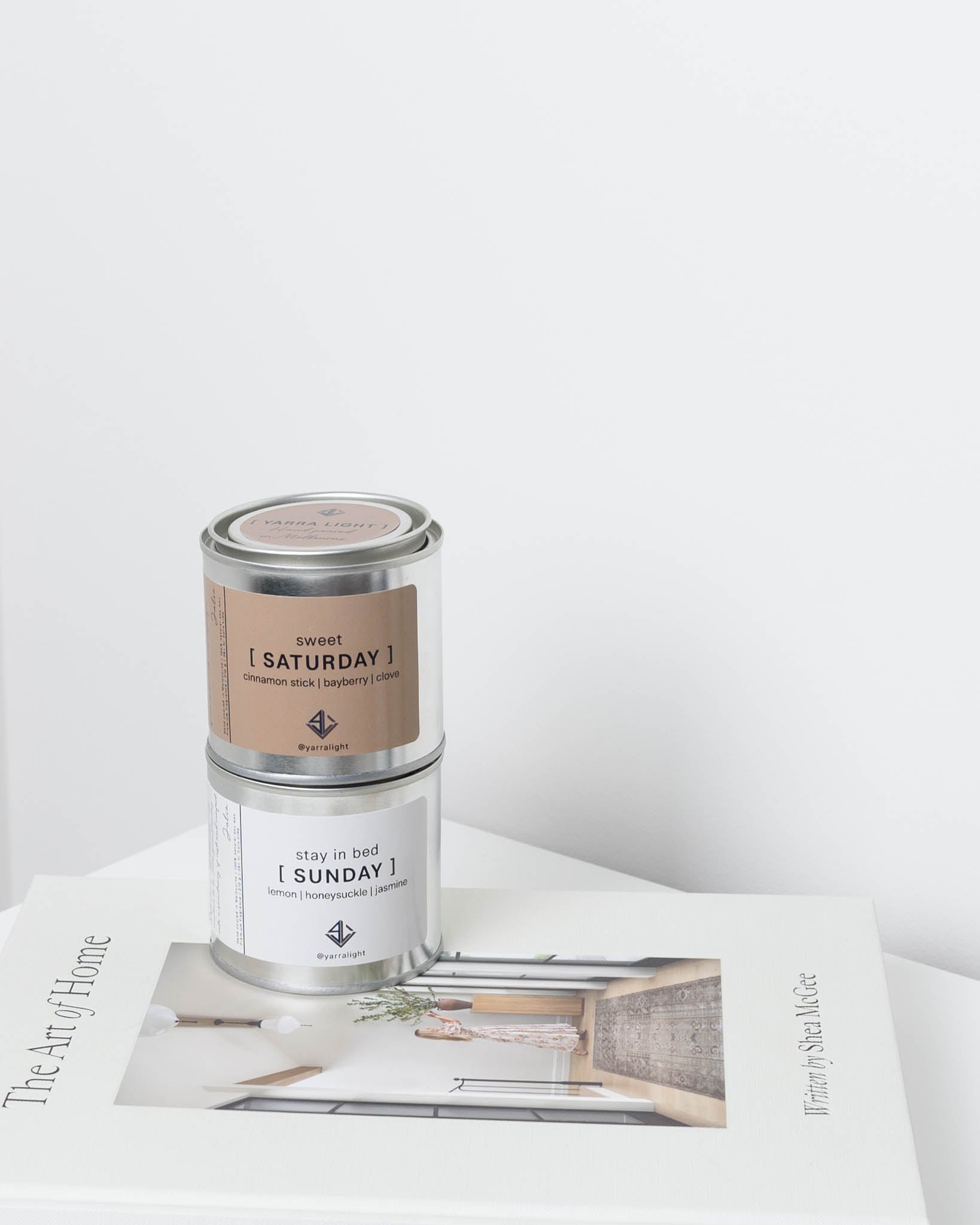 Two candles labeled 'Saturday' and 'Sunday' on a magazine with a white background