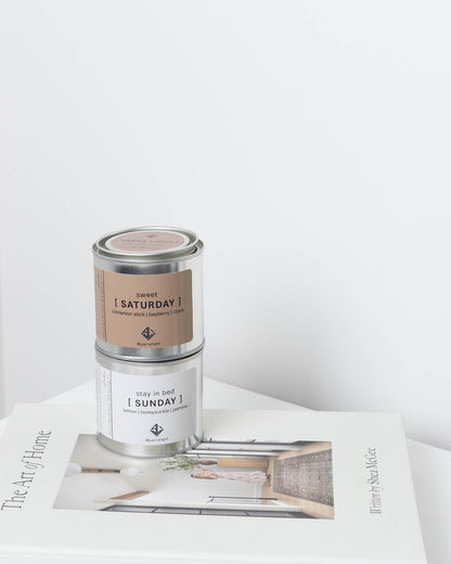 Two candles labeled 'Saturday' and 'Sunday' on a magazine with a white background
