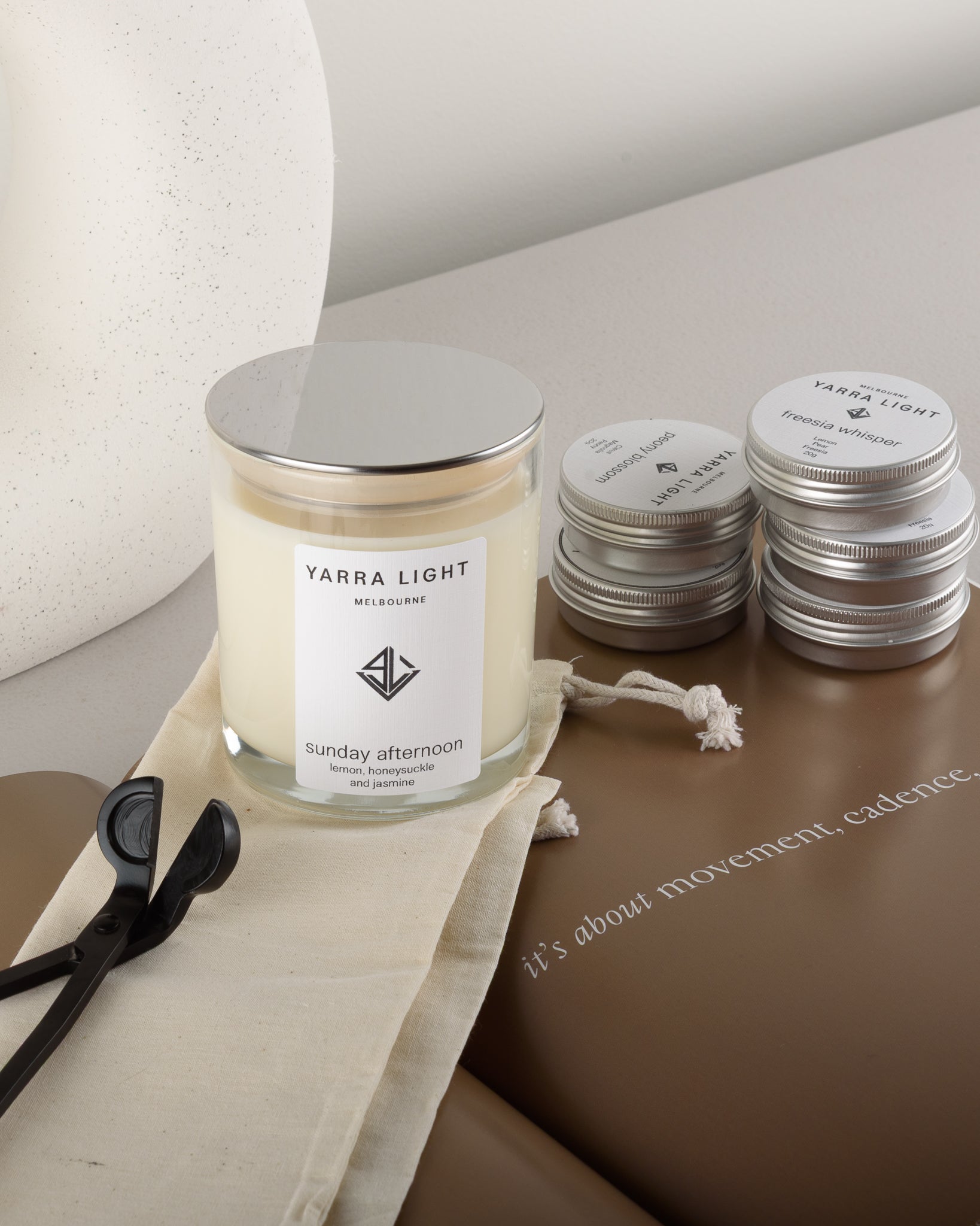 Candle starter kit featuring five soy wax scented sample candle tins, one Sunday Afternoon soy wax scented candle in a clear glass jar with minimalist label, and a metal wick trimmer, all arranged for an ideal beginner’s candle experience or gift set.