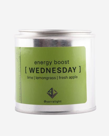 Candle jar labeled 'energy boost Wednesday' with a green label on a white background